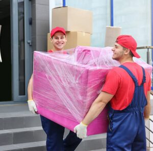 Zwei Umzugshelfer tragen ein in Folie gepacktes Möbelstück – Umzug in Weinheim