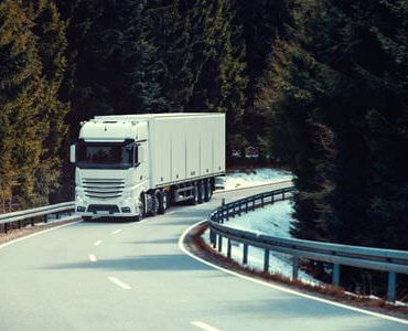 Pianotransport Pianotransport: Lkw fährt auf einer kurvigen Straße durch den Wald